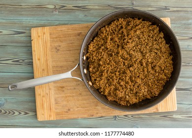 Kitchen Skillet Filled With Savory Seasoned Cooked Ground Beef For Sloppy Joe Tacos In An Overhead View On A Chopping Board