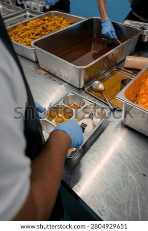 Kitchen staff preparing nutritious meal portions for the Indonesian Makan Bergizi Gratis program, ensuring healthy and hygienic food supply for students. MBG indonesia.