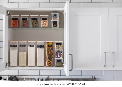 Kitchen storage organization use plastic case. Placing and sorting food products into pp box. Keeping organizing at modern kitchen interior in Nordic style. General cleaning, tidying up at cuisine - Shutterstock ID 2018743424