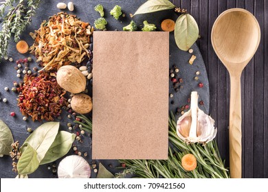 Kitchen table with ingredients, utensils and menu free space blank for your design app over cooking book on wooden table. Top view. Recipe and menu background. flat lay. Mock up. Free copy space.