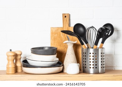 Kitchen table, kitchen utensils, plates, bowls, shakers and wooden cutting board. - Powered by Shutterstock