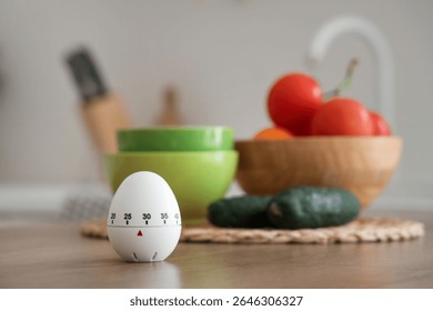Kitchen timer and vegetables on table in room, closeup