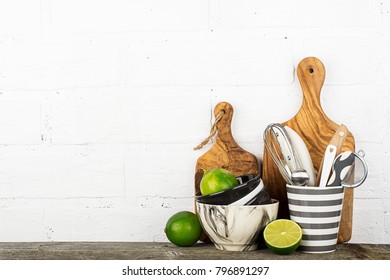 Kitchen tools, olive cutting board on a kitchen shelf against a white brick wall. selective focus.