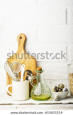 Kitchen tools, olive cutting board on a kitchen shelf against a white brick wall. selective