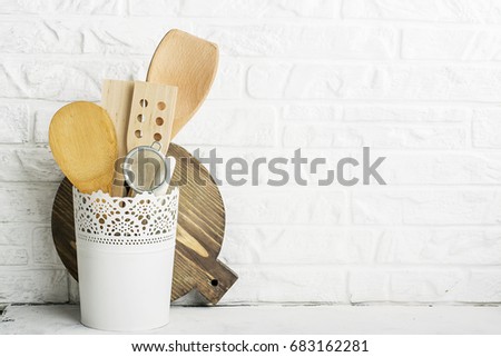 Kitchen tools, olive cutting board on a kitchen shelf against a white brick wall. selective focus.