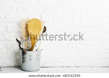 Kitchen tools, olive cutting board on a kitchen shelf against a white brick wall. selective focus.