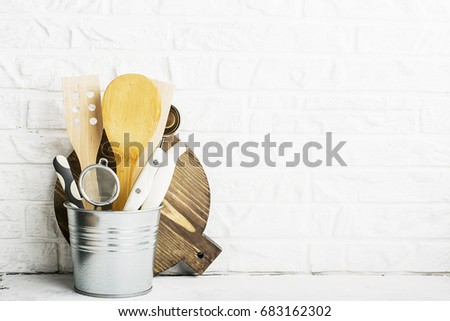 Kitchen tools, olive cutting board on a kitchen shelf against a white brick wall. selective focus.