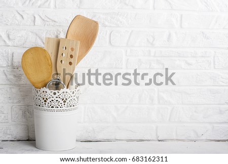 Kitchen tools, olive cutting board on a kitchen shelf against a white brick wall. selective focus.