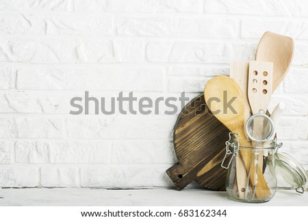 Kitchen tools, olive cutting board on a kitchen shelf against a white brick wall. selective focus.