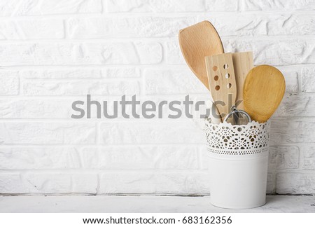 Kitchen tools, olive cutting board on a kitchen shelf against a white brick wall. selective focus.