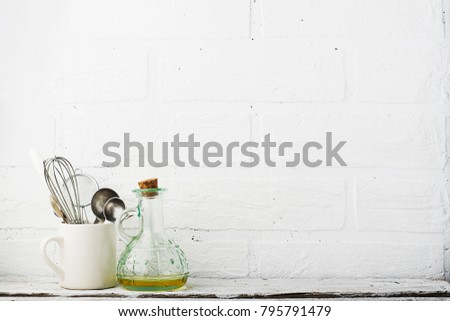 Kitchen tools, olive cutting board on a kitchen shelf against a white brick wall. selective focus,