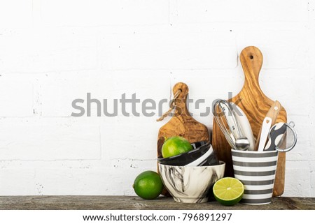 Kitchen tools, olive cutting board on a kitchen shelf against a white brick wall. selective focus.
