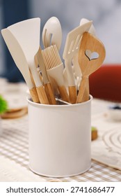 Kitchen tools stored in a white container on a table