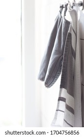 Kitchen Towel And A Pair Of Oven Gloves Hanging On A Tile Wall Back Light Desaturated Colors 2020