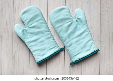 Kitchen turquoise oven mitts mockup design on white old wooden background with copy space for text.