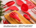 Kitchen utensils background with copyspace, home kitchen decor concept, kitchen tools, rubber accessories in container. Restaurant, cooking, culinary, kitchen theme. Silicone spatulas and brushes, Red