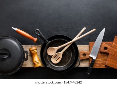 Kitchen utensils dark background with cast iron black kitchenware, top down view, blank space for a text - Shutterstock ID 1547448242