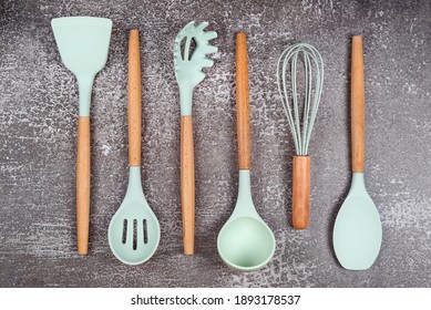 Kitchen utensils, home kitchen tools, mint rubber accessories on dark background. Restaurant, cooking, culinary, kitchen theme. Silicone spatulas and brushes, free space for text.