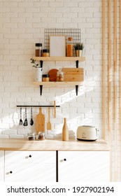 Kitchen utensils and utensils on a wooden countertop. Stylish kitchen interior in white and beige tones, spring background