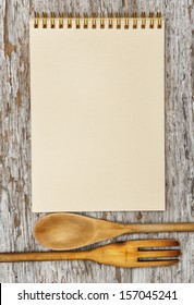 Kitchen Utensils And Paper Spiral Notebook On The Old Wood