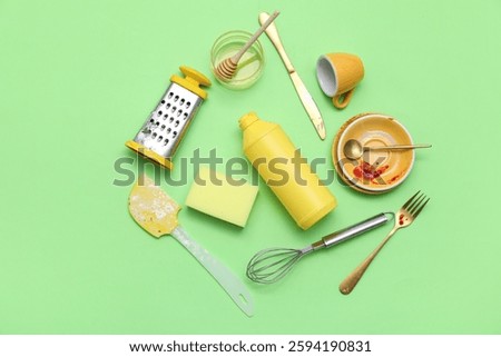 Kitchen utensils, sponge and detergent on green background. Top view