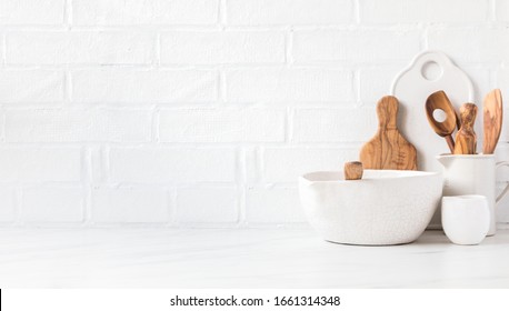 Kitchen utensils,tools  and dishware on on the background white  brick wall.Interior, modern kitchen space in bright colors.Blank space for a text, front view - Shutterstock ID 1661314348