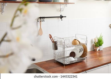 Kitchen with various kitchen tools, background with kitchen racks and plants. The appearance of drying dishes and bowls.
