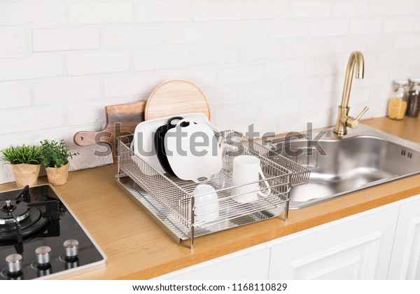 Kitchen with various kitchen tools, background\
with kitchen racks and plants. The appearance of drying dishes and\
bowls.