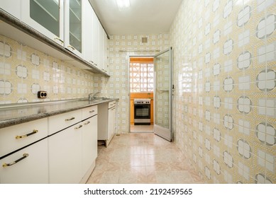 Kitchen With White Cabinets, Gray Countertops And Vintage Kitsch Tiles With Access To A Terrace