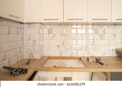 Kitchen With Wooden Worktop, White Cabinets And White Metro Tiles Under Reconstruction