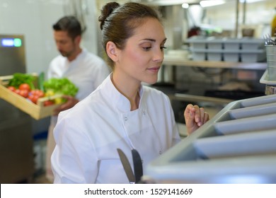 kitchen worker taking cutlery out - Powered by Shutterstock