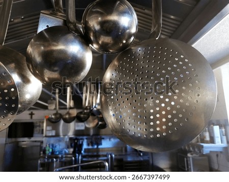 Kitchenware hangs from the ceiling of a commercial kitchen