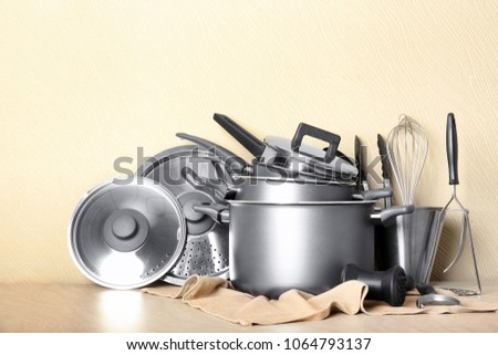 Kitchenware prepared for cooking classes on table against light wall