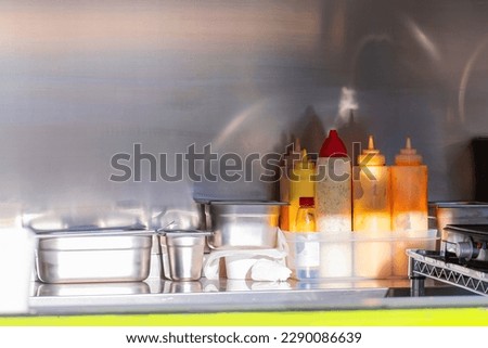 Kitchenware, trays and different bottle dosages of sauces in a food truck van