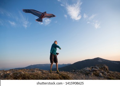 Kite Flying. The Boy Launches A Kite. Beautiful Sunset. Mountains, Sea, Landscape. Summer Day, Sunny. Eagle Kite