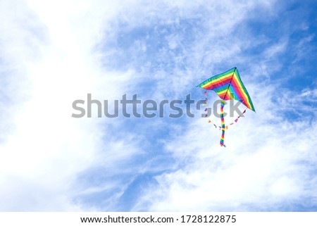 
kite in hand on blue sky in sunny weather and wind. Kite flying in summer with copy space. 
Freedom. Summer games and fun