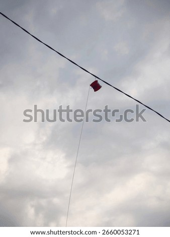 Kite string spool caught on wire above the rooftop.
