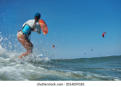 Kite Surfer Woman Jumps With Kiteboard  In Transition And Throws Up The Board