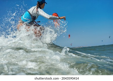 Kite Surfer Woman Jumps With Kiteboard  In Transition And Throws Up The Board