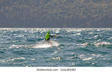 Kite Surfing On A Lake In Patagonia, With A Helmet And Yellow Clothes