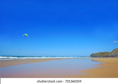 Kite Surfing On Waves In Watergate Bay On A Beautiful Blue Sky Summer Day, Cornwall, England, UK