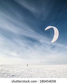 Kiteboarder With Blue Kite On The Snow