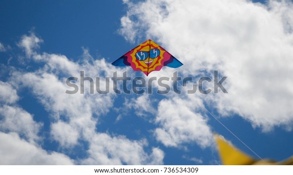 Kites in the sky. Colorful kites flying in\
blue sky. Under the blue sky flying\
kites