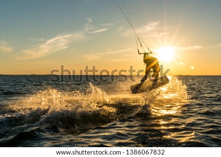 kitesurfer doing tricks in sunset