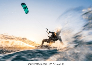 Kitesurfer surfing in sunset conditions with blue water and motion blur at the baltic sea - Powered by Shutterstock