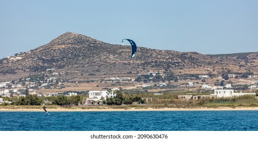 Kitesurfing in Aegean blue sea at Pounta beach Paros island Cyclades Greece. Kiteboarding, extreme sport speed adventure. 