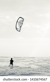 Kitesurfing in the Ionian Sea in the marina of Lizzano in southern Italy, very rough sea, interpretation of the vintage shot, vertical format.