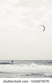 Kitesurfing in the Ionian Sea in the marina of Lizzano in southern Italy, very rough sea, interpretation of the vintage shot, vertical format.