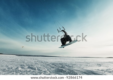 kiting on a snowboard on a frozen lake