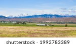 The Kittitas Valley in late Spring as the Cascade Mountains rise above the wind farm in the foothills.  The agriculture land begins it annual cycle of production